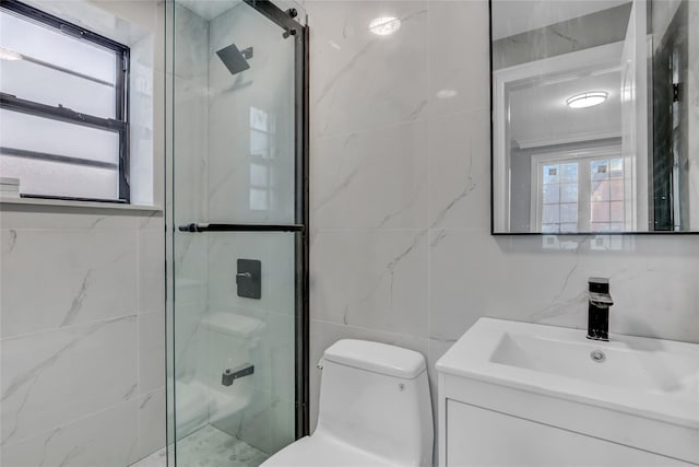 bathroom featuring vanity, plenty of natural light, a shower with shower door, and tile walls