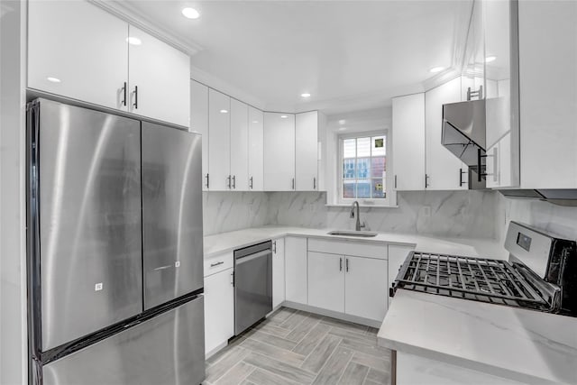 kitchen with white cabinetry, sink, stainless steel appliances, decorative backsplash, and light parquet flooring