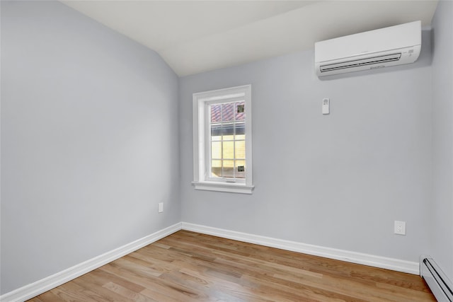 unfurnished room with vaulted ceiling, light wood-type flooring, an AC wall unit, and a baseboard heating unit