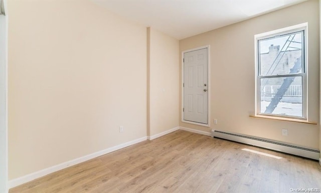 spare room featuring light hardwood / wood-style flooring and a baseboard heating unit