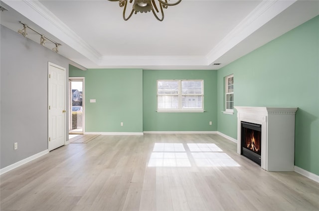 unfurnished living room with a raised ceiling, ceiling fan, crown molding, and light hardwood / wood-style floors