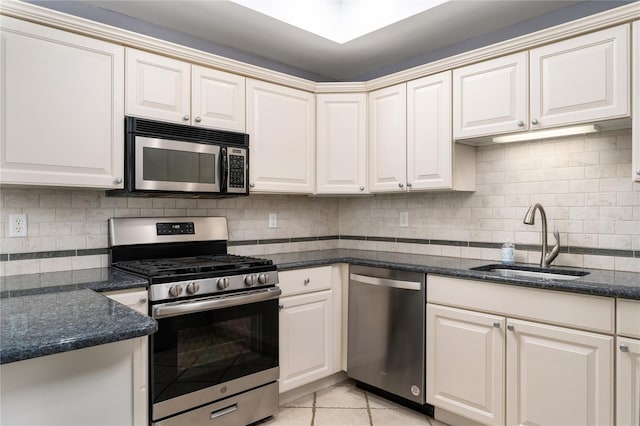 kitchen with decorative backsplash, appliances with stainless steel finishes, light tile patterned floors, and sink