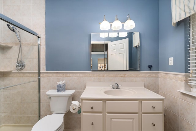 bathroom featuring vanity, toilet, tile walls, and a tile shower