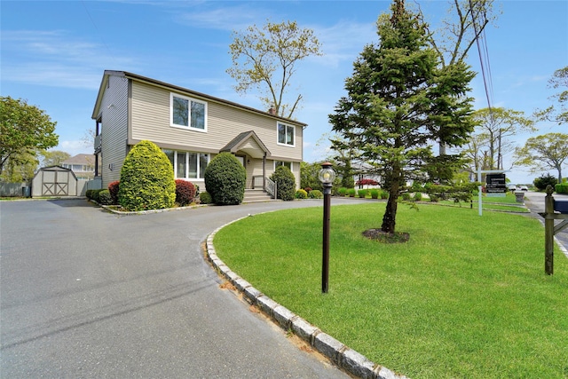 view of front of property with a storage unit and a front lawn