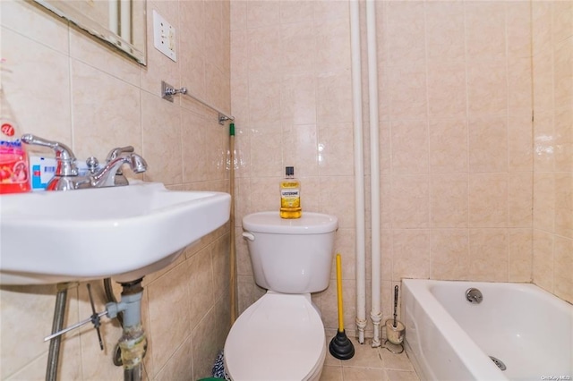 bathroom featuring tile patterned flooring, toilet, tile walls, and a tub