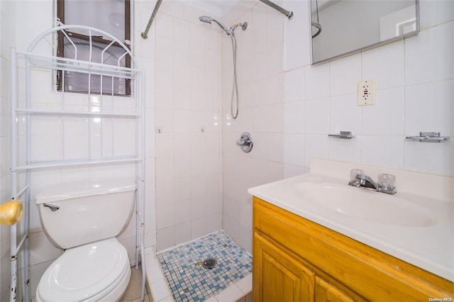 bathroom featuring toilet, vanity, tile walls, and tiled shower