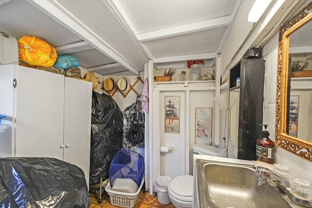 bathroom with sink, parquet floors, and toilet