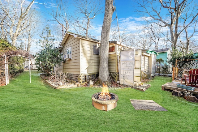 exterior space featuring an outdoor fire pit and a lawn