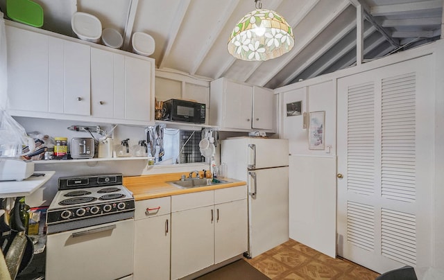 kitchen featuring range with electric stovetop, vaulted ceiling, pendant lighting, white fridge, and white cabinets