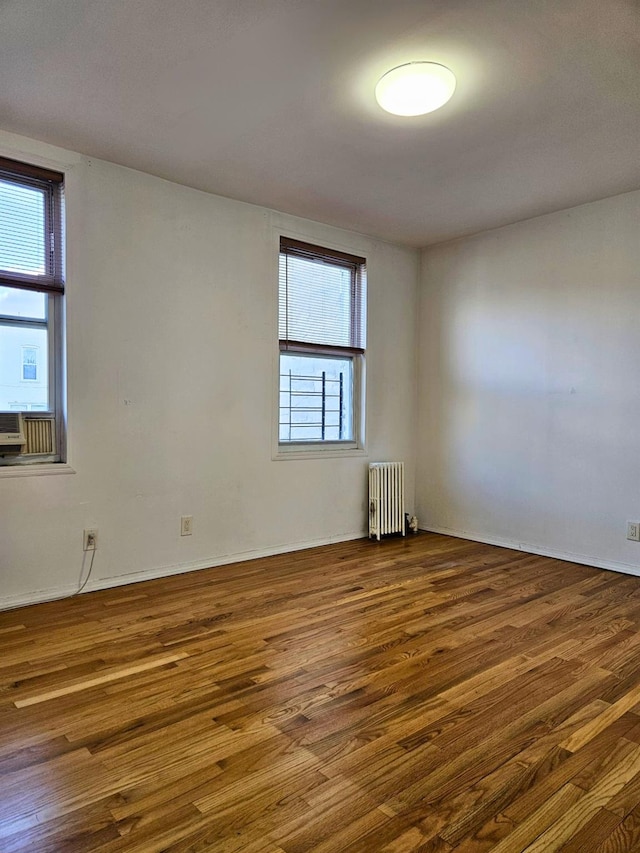 spare room with radiator and dark hardwood / wood-style flooring