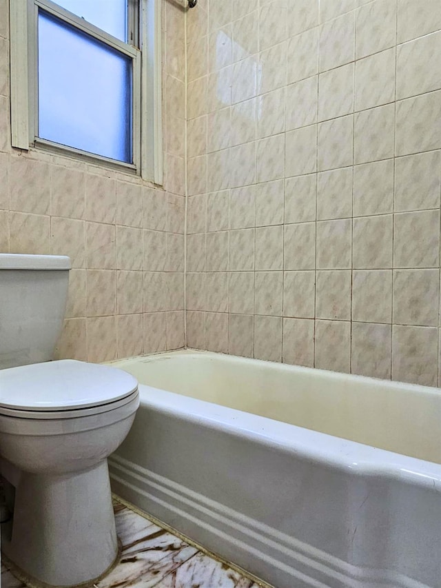 bathroom with tile walls and toilet