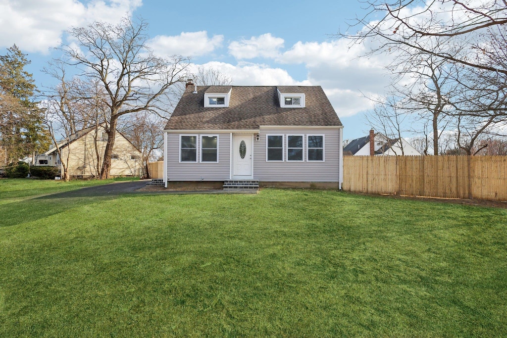 cape cod house with a front yard