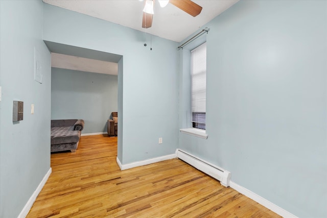 spare room with baseboard heating, ceiling fan, and light hardwood / wood-style floors