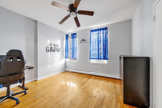 home office with ceiling fan, baseboard heating, and hardwood / wood-style flooring