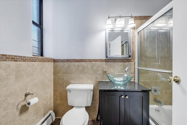 full bathroom featuring tile walls, tiled shower / bath, vanity, and toilet