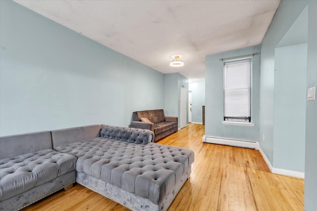 living room with a baseboard radiator, a textured ceiling, and hardwood / wood-style floors