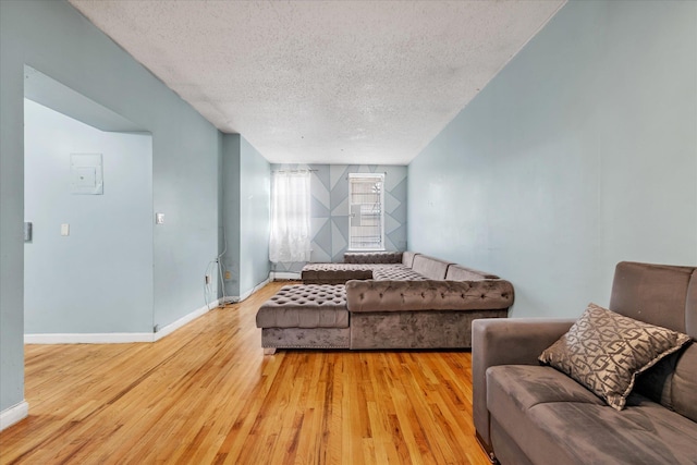 living room with a textured ceiling and wood-type flooring