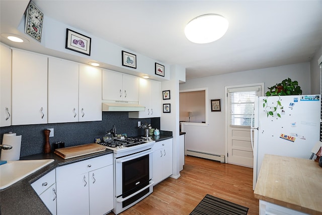 kitchen with tasteful backsplash, white appliances, baseboard heating, sink, and white cabinets