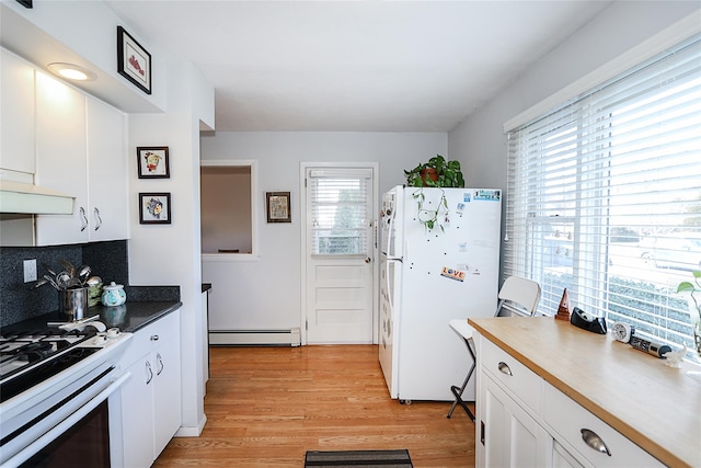 kitchen featuring white appliances, decorative backsplash, light wood-type flooring, a baseboard radiator, and white cabinetry