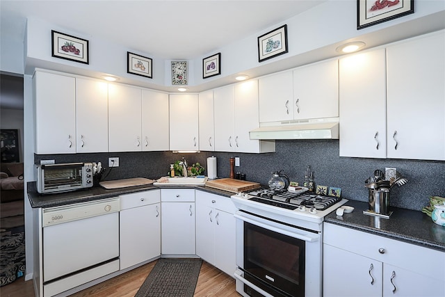 kitchen featuring white cabinets, white appliances, and tasteful backsplash