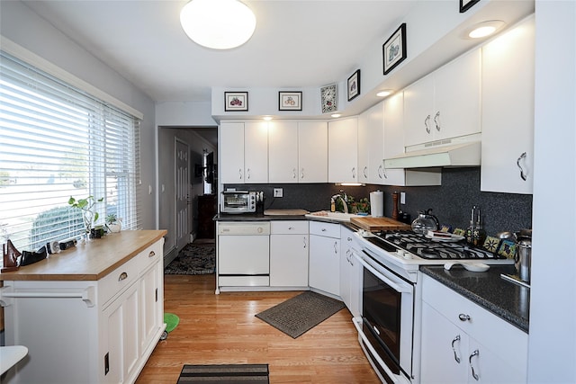 kitchen with white cabinets, white appliances, light hardwood / wood-style flooring, and tasteful backsplash