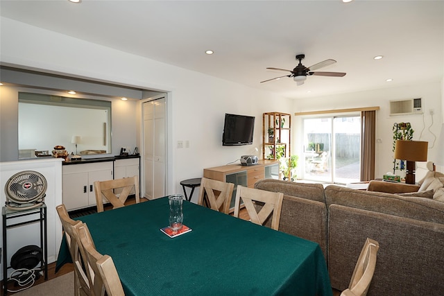 dining space with ceiling fan and a wall mounted AC