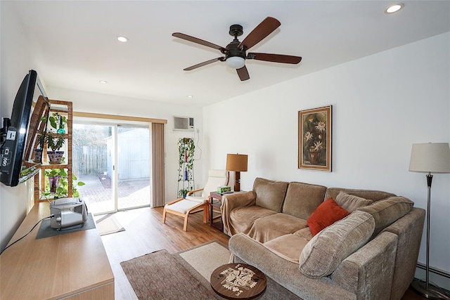 living room with a wall mounted AC, ceiling fan, light hardwood / wood-style floors, and a baseboard heating unit