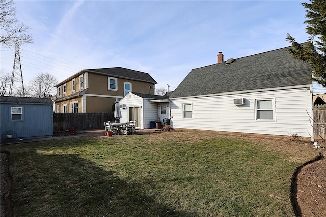 rear view of property with a lawn, a patio area, and a storage shed