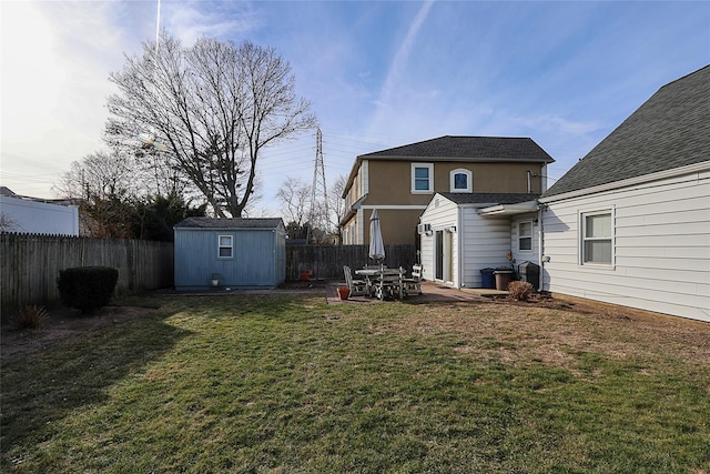 rear view of property featuring a lawn, a patio, and a shed