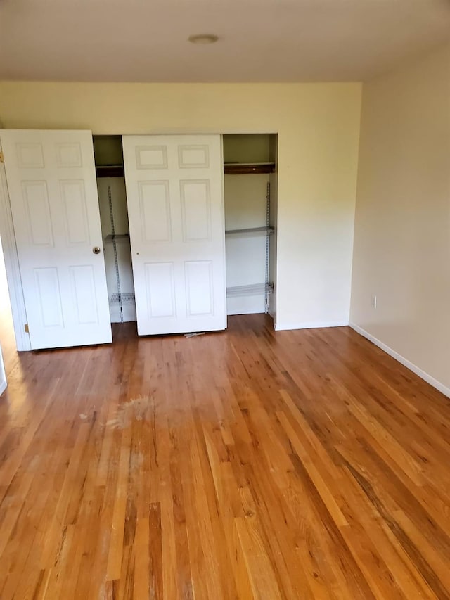 unfurnished bedroom with hardwood / wood-style floors and a closet