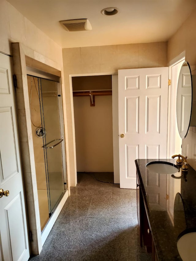 bathroom featuring vanity and an enclosed shower