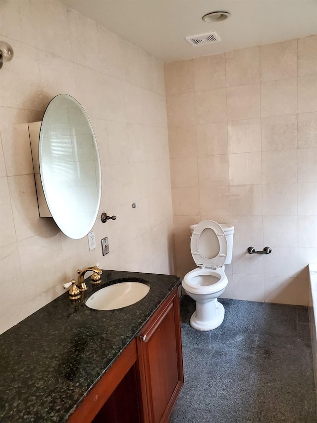 bathroom with decorative backsplash, vanity, tile walls, and toilet