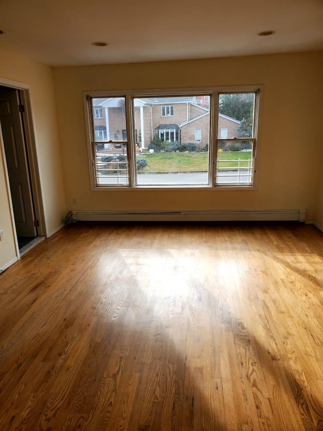 empty room featuring light hardwood / wood-style floors and a baseboard radiator