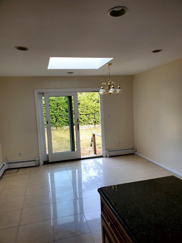 tiled spare room featuring a baseboard radiator, a skylight, and a notable chandelier