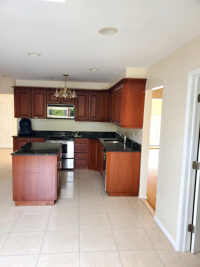 kitchen featuring stainless steel appliances, sink, light tile patterned floors, a chandelier, and a center island