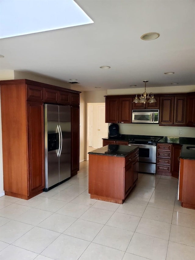 kitchen featuring light tile patterned floors, a notable chandelier, pendant lighting, a kitchen island, and appliances with stainless steel finishes