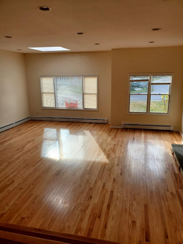 unfurnished room with light hardwood / wood-style flooring and baseboard heating