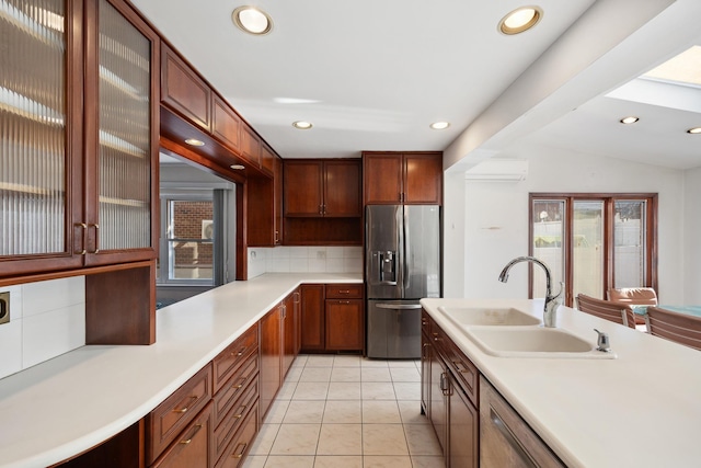 kitchen with sink, stainless steel refrigerator with ice dispenser, a wall mounted AC, decorative backsplash, and light tile patterned flooring