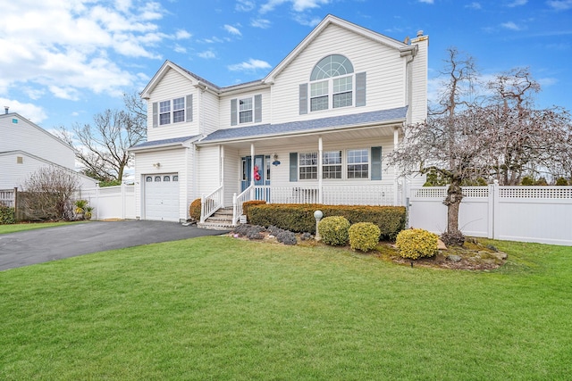 view of property with a garage, a front yard, and a porch