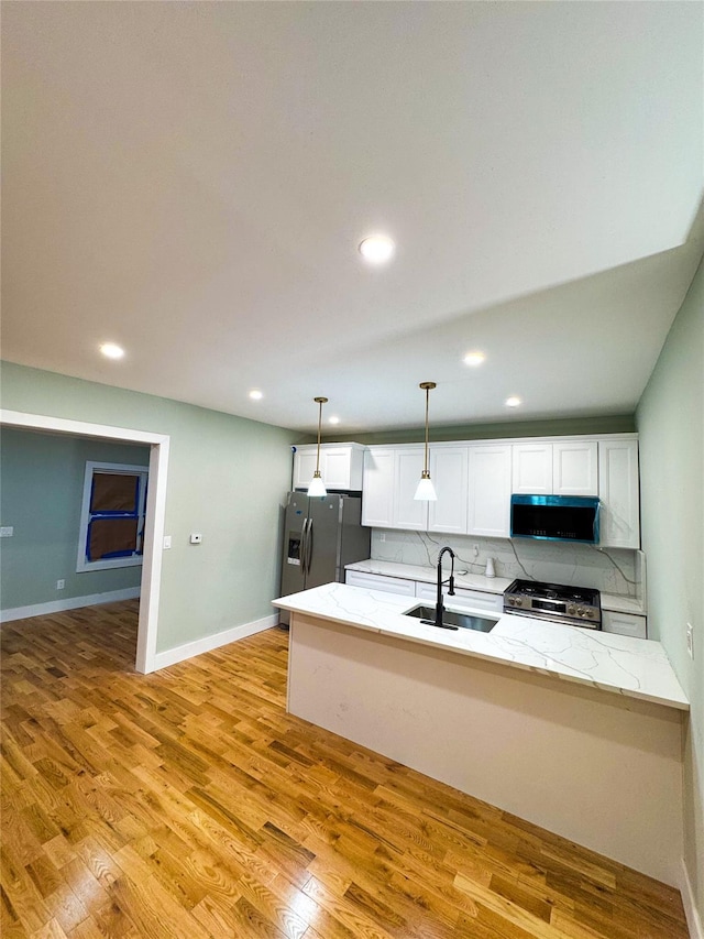 kitchen with backsplash, stainless steel appliances, sink, pendant lighting, and white cabinets