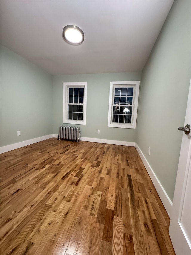 empty room with light wood-type flooring and radiator