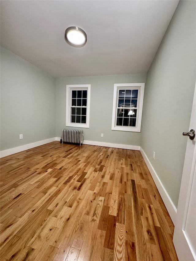 unfurnished room with light wood-type flooring and radiator