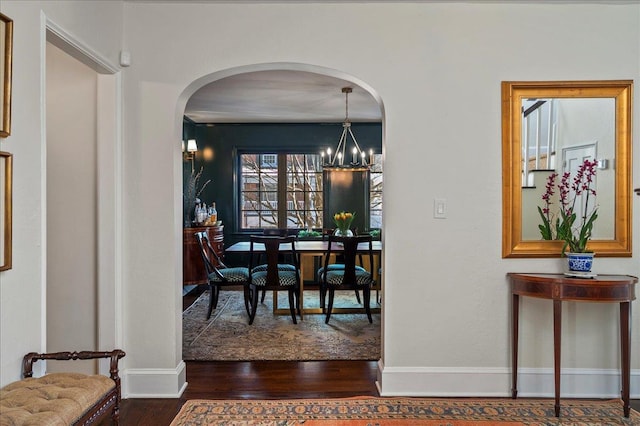 dining room with an inviting chandelier and dark wood-type flooring