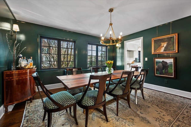 dining space with hardwood / wood-style floors and a notable chandelier