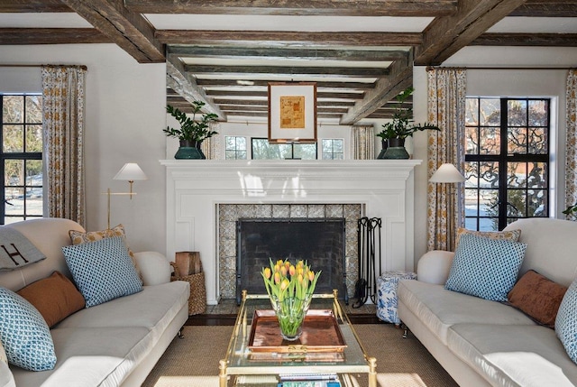 living room with a tiled fireplace and beam ceiling