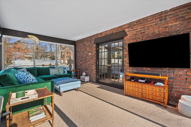 carpeted living room featuring brick wall and french doors