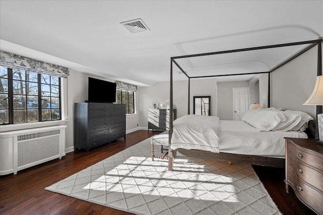 bedroom featuring radiator heating unit and dark hardwood / wood-style floors