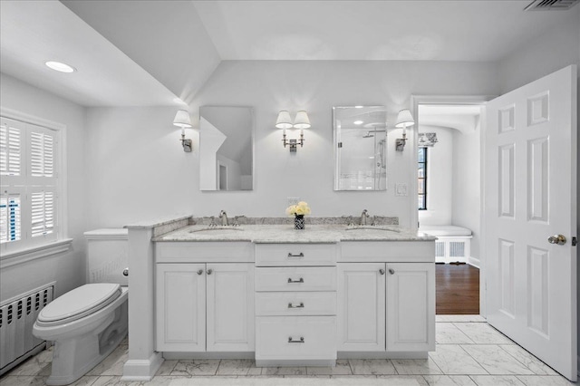 bathroom featuring vanity, toilet, and radiator