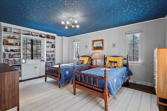 bedroom featuring ornamental molding, a notable chandelier, and light hardwood / wood-style flooring