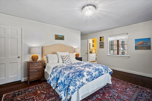 bedroom featuring ensuite bathroom and dark hardwood / wood-style floors